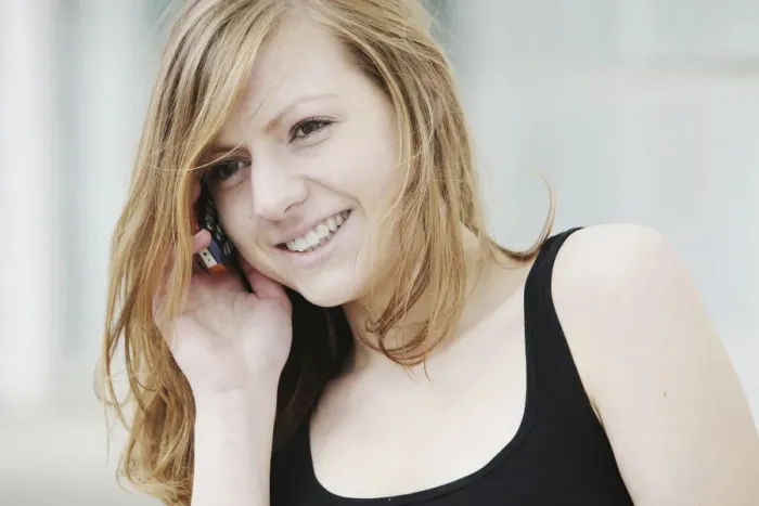 Framed Print : Young woman speaking on her mobile phone, smiling Framed Print : Young woman speaking on her mobile phone, smiling
