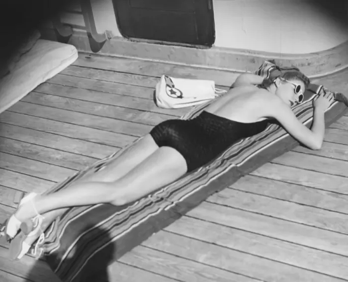 Framed Print : Young woman sun tanning on cruiser deck (B&W), elevated view Framed Print : Young woman sun tanning on cruiser deck (B&W), elevated view