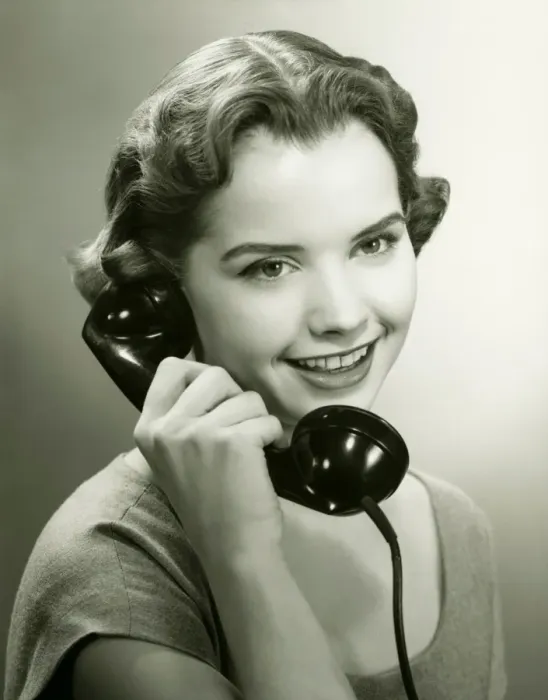 Framed Print : Young woman talking on phone in studio, (B&W), portrait Framed Print : Young woman talking on phone in studio, (B&W), portrait