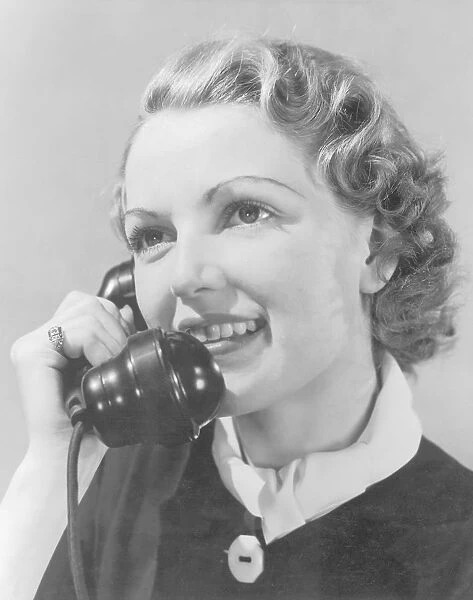 Young woman using telephone, close-up (B&W)