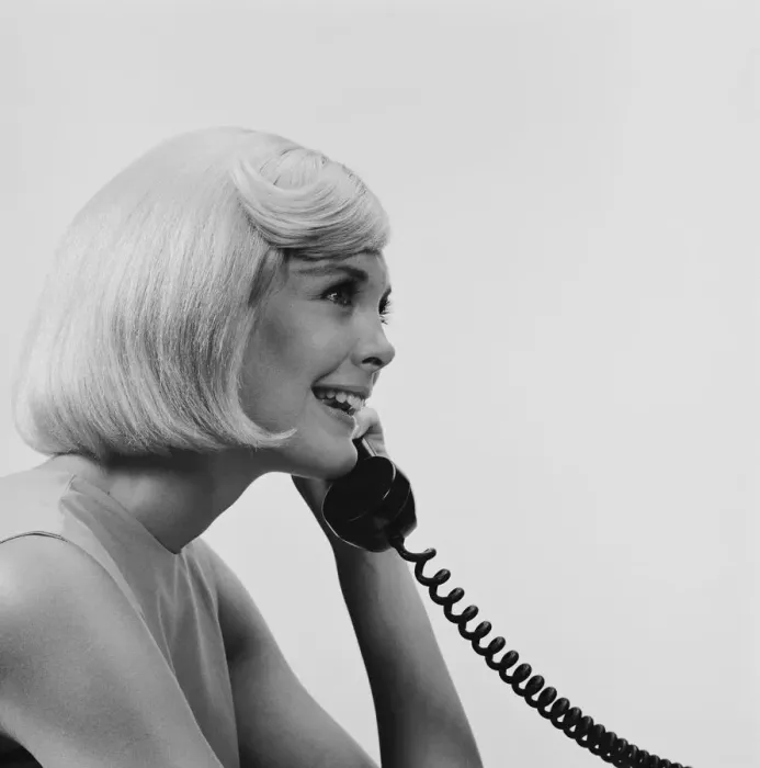 Framed Print : Young woman using telephone, smiling Framed Print : Young woman using telephone, smiling