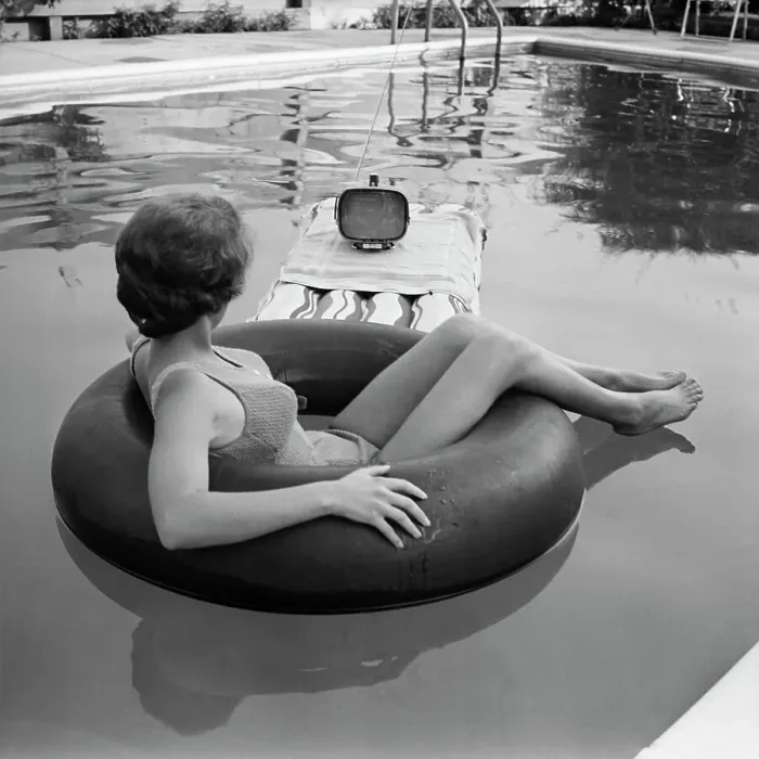 Framed Print : Young Woman Watches Television in the Pool Framed Print : Young Woman Watches Television in the Pool
