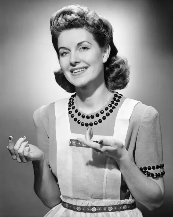 Framed Print : Young woman wearing apron, standing, smiling, (B&W) Framed Print : Young woman wearing apron, standing, smiling, (B&W)