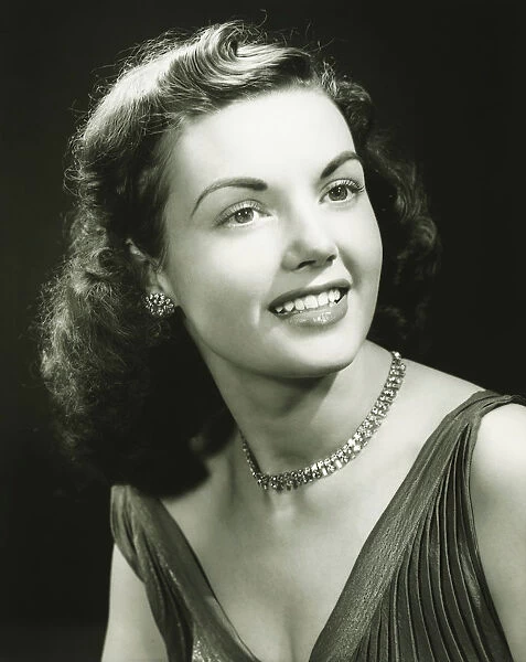 Young woman wearing evening dress, smiling, (B&W), close-up