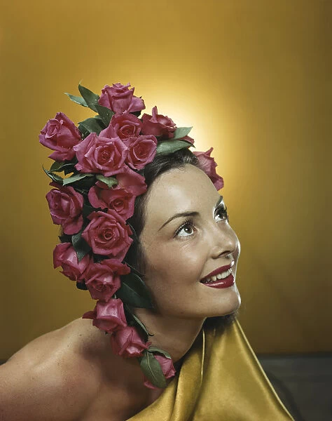 Young woman wearing flowers in hair, smiling, close-up