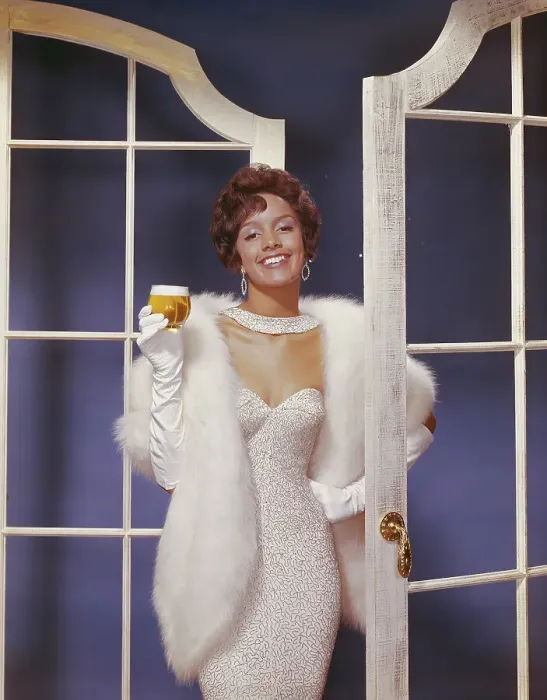 Framed Print : Young woman wearing fur jacket holding beer glass, smiling, portrait Framed Print : Young woman wearing fur jacket holding beer glass, smiling, portrait