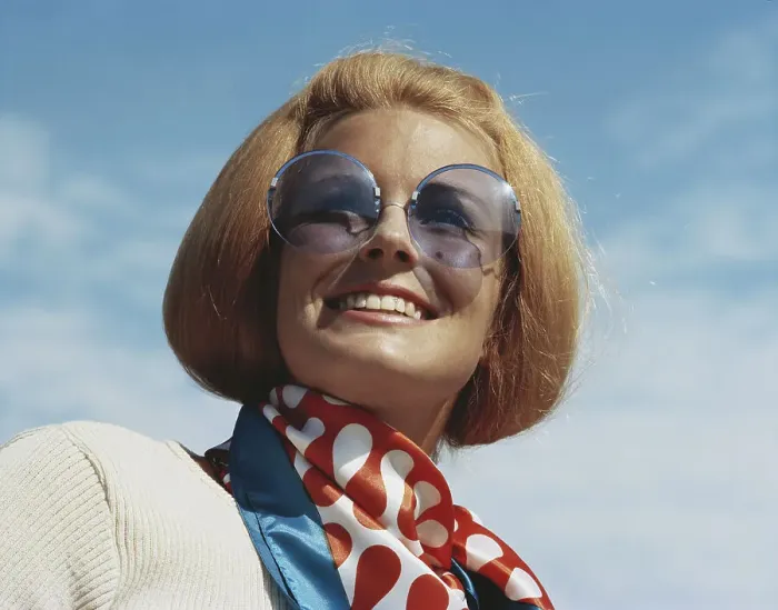 Framed Print : Young woman wearing sunglasses, smiling, close-up Framed Print : Young woman wearing sunglasses, smiling, close-up