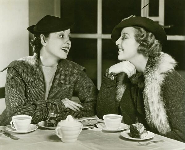 Two young women chatting, having coffee and cake, (B&W)