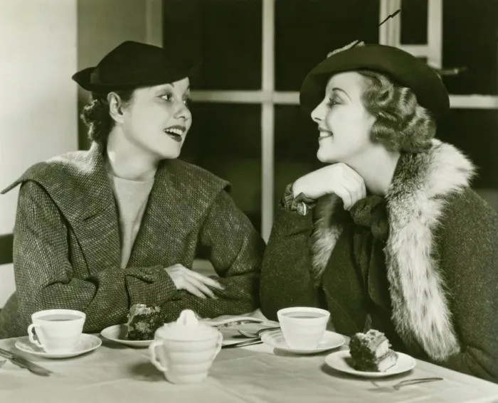 Framed Print : Two young women chatting, having coffee and cake, (B&W) Framed Print : Two young women chatting, having coffee and cake, (B&W)