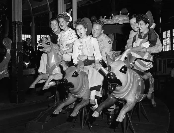 Framed Print : Young women and men enjoying ride on carousel