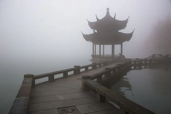 A zig zag bridge and a Pavilion on the West Lake in foggy morning, Hangzhou