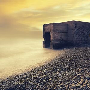 Abandoned bunker on the beach at sunrise