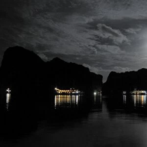 Anchored Junk boats in Halong Bay at night