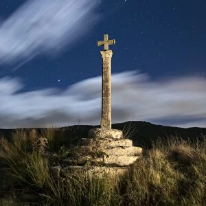 Ancient monument of medieval epoch in the shape of cross, illuminated by the moonlight