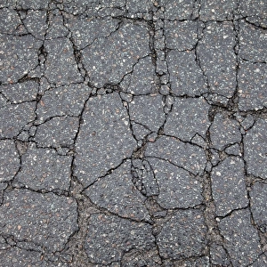 Asphalt cracked by frost and cold, potholes in Berlin, Germany, Europe