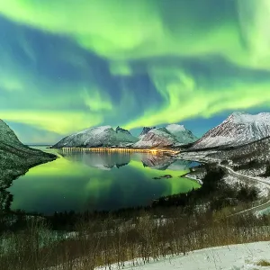 The aurora borealis lights up in the sky and is reflected in the fjord. Northern Norway, Europe The aurora borealis lights up in the sky and is reflected in the fjord. Northern Norway, Europe