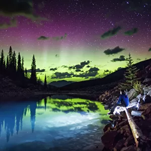 The aurora borealis above the turquoise waters of Moraine Lake, Banff National Park, Alberta, Canada