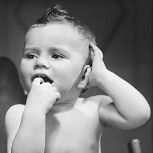 Baby boy (9-12 months) with finger in mouth (B&W)