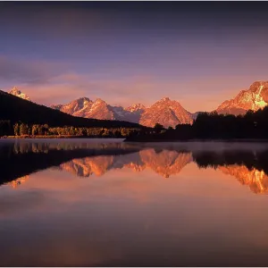 A beautiful coloured dawn casts its glow over Jackson lake in the Grand Tetons, Wyoming A beautiful coloured dawn casts its glow over Jackson lake in the Grand Tetons, Wyoming
