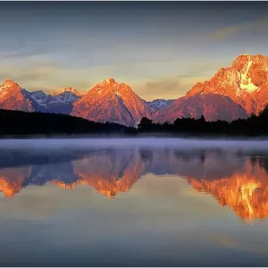 A beautiful coloured dawn casts its glow over Jackson lake in the Grand Tetons, Wyoming A beautiful coloured dawn casts its glow over Jackson lake in the Grand Tetons, Wyoming