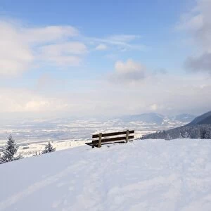 Bench on a mountain peak, snow-covered Rosenheim Basin and Chiemgau Alps at back, Leitzachtal, bei Elbach, Upper Bavaria, Bavaria, Germany
