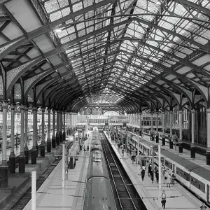 Black and white photograph of railroad tracks and platforms, interiors of Liverpool Street Station in London, England