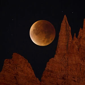 Blood Moon over jagged mountains