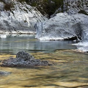 Boulders and rocks in the river bed of the golden coloured Soca river in Soca Valley near Bovec, Triglav National Park, Slovenia, Europe
