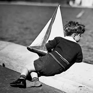 Boy playing with toy sailboat