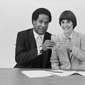 Businessman and woman toasting drink glass, smiling, portrait