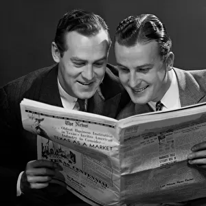Two businessmen reading newspaper