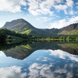 Buttermere lake early morning reflections. A beautiful summer morning with Fleetwith Pike and Haystacks mountains covered in purple heather. Lake District National park. UK. Europe