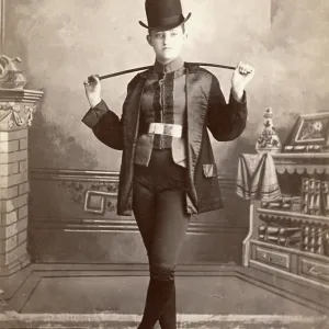 Cabinet card portrait of woman dressed in a man's horse riding suit and crop