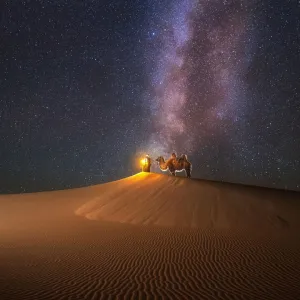 Camel herder under beautiful milky way in Mongolian Gobi desert