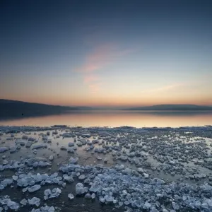 Chunks of ice lying on icy surface on the shore of Reichenau Island after sunset, Baden-Wuerttemberg, Germany, Europe Chunks of ice lying on icy surface on the shore of Reichenau Island after sunset, Baden-Wuerttemberg, Germany, Europe