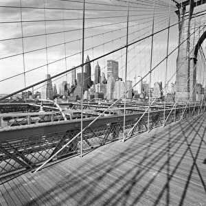 Cityscape through bridge cables, negative image