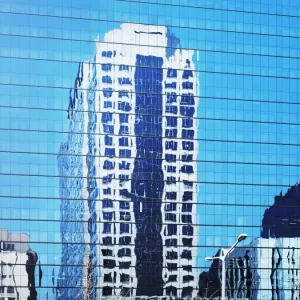 Cityscape reflected in glass facade of building Cityscape reflected in glass facade of building