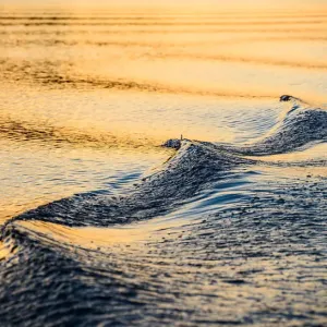 A closeup of a wave and wake in the refelcted suns A closeup of a wave and wake in the refelcted suns
