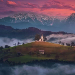 Colourful and foggy autumn sunrise at Saint Thomas Church, Skofja Loka, Upper Carniola, Slovenia