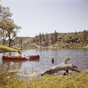 Couple fishing from canoe in lake
