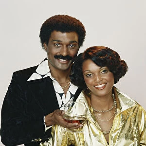 Couple holding wine glass against white background, close-up, portrait