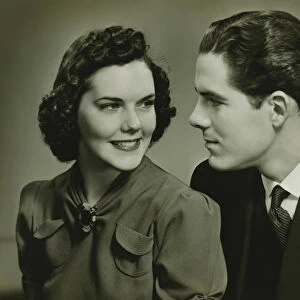 Couple looking in eyes, posing in studio, (B&W), portrait