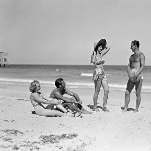 Two couples standing on beach
