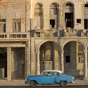 Cuba, Havana, blue car passing building on street