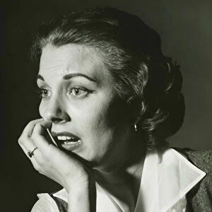 Distressed woman posing in studio, (B&W), portrait