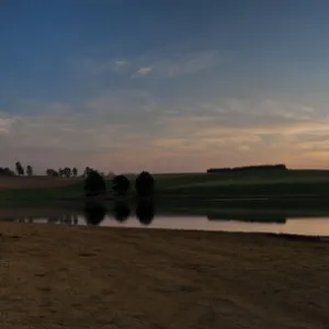 Dramatic panoramic sunset landscape photo over a peaceful remote and isolated farm lake. Kwazulu-Natal, South Africa