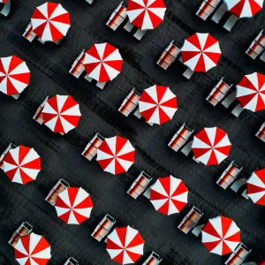 Drone image directly above beach umbrellas, Massa, Italy