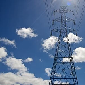 Electricity pylon against a blue sky with clouds