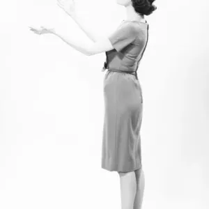 Elegant woman standing in studio, gesturing, (B&W) Elegant woman standing in studio, gesturing, (B&W)