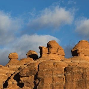 Eroded rock formations at sunset in Arches National Park with clouds, Utah, USA